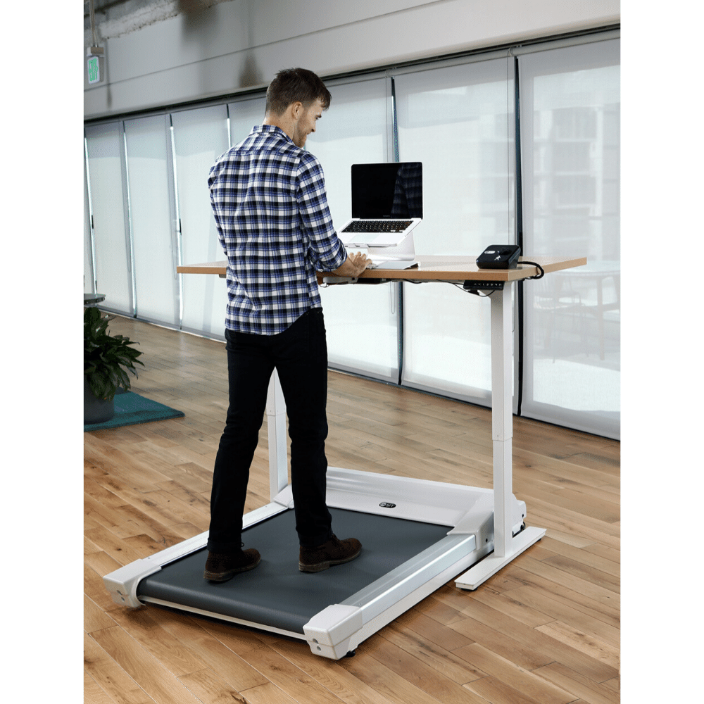 A photo of a man walking on the Unsit Treadmill in an office
