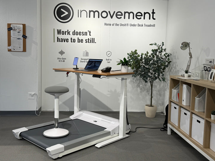 Office setup with treadmill desk and 'inmovement' branding, showing the Energy Stool paired with the treadmill desk workstation