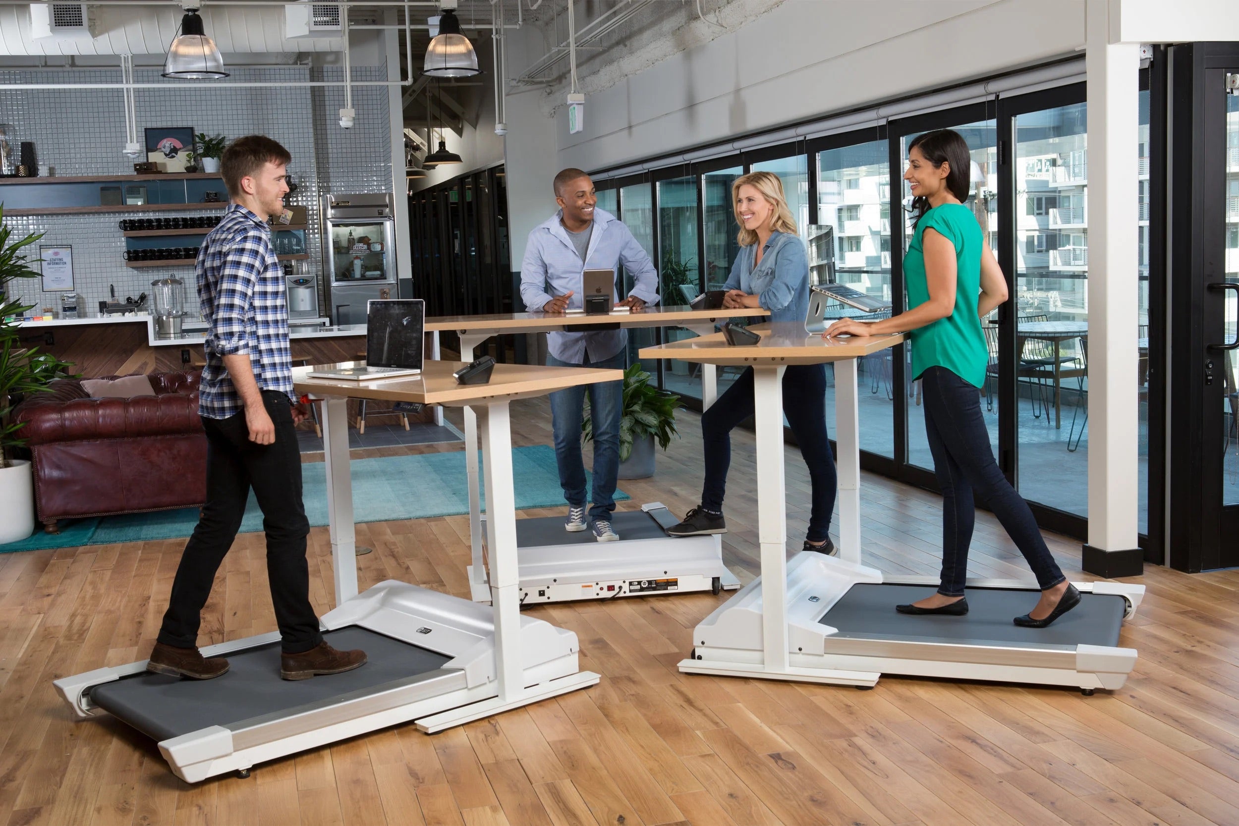 People using treadmill desks in a modern office setting