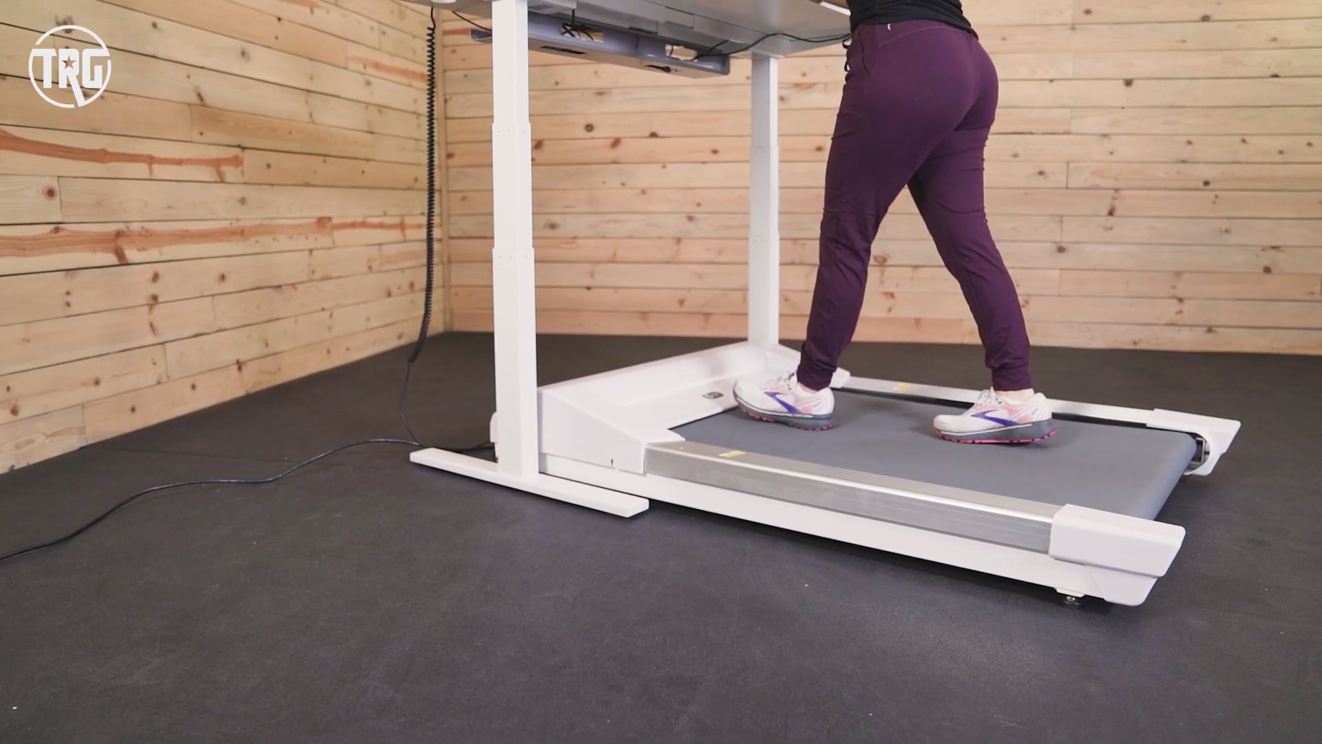 A video from Treadmill Review Guru reviewing the Unsit Under Desk Treadmill in a room with wood paneling